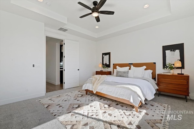 bedroom featuring baseboards, recessed lighting, carpet floors, visible vents, and a tray ceiling