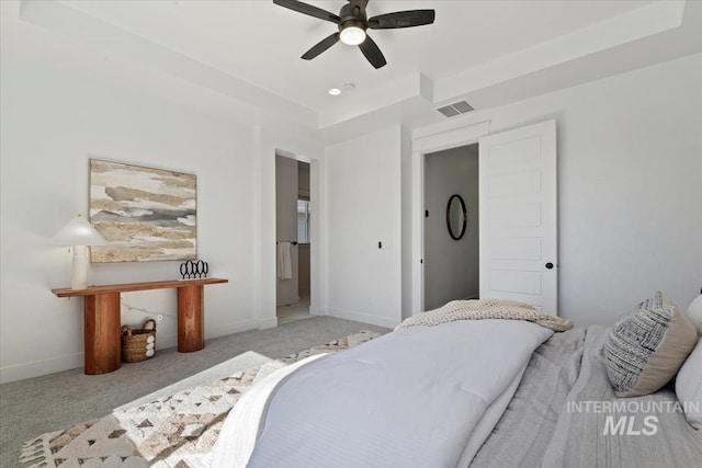 bedroom with visible vents, baseboards, a raised ceiling, ceiling fan, and carpet