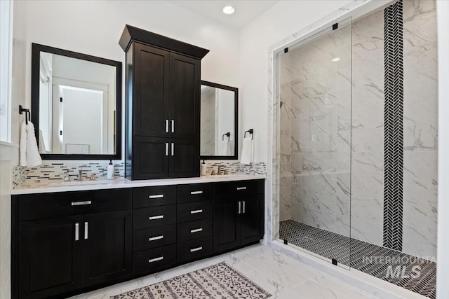full bathroom featuring tasteful backsplash, double vanity, a marble finish shower, marble finish floor, and a sink