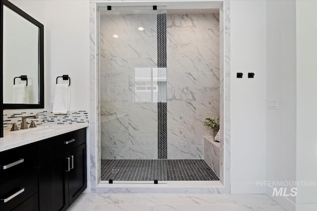 full bath featuring marble finish floor, vanity, and a marble finish shower