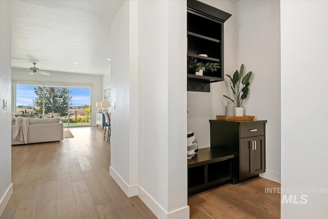 hallway with baseboards and light wood finished floors