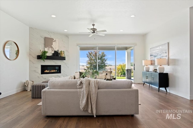 living room featuring wood finished floors, recessed lighting, a ceiling fan, and a premium fireplace
