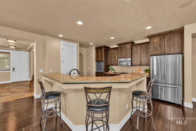 855 N Morley Green Pl, Eagle, ID 83616 - kitchen with baseboards, a breakfast bar area, stainless steel appliances, and dark wood-type flooring