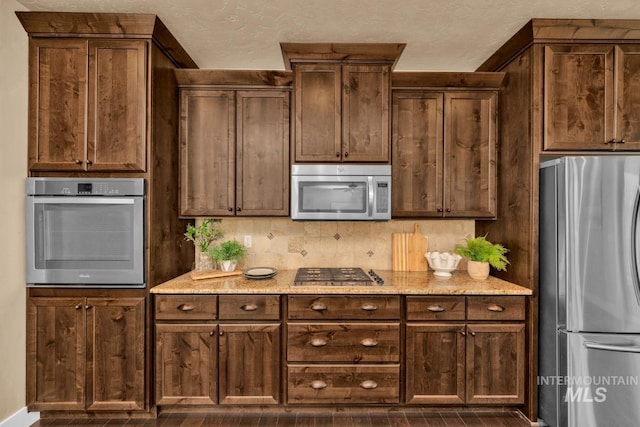 855 N Morley Green Pl, Eagle, ID 83616 - kitchen featuring appliances with stainless steel finishes, baseboards, dark wood finished floors, and light stone counters
