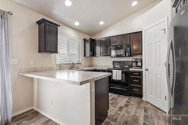 868 S Wiston Pl, Kuna, ID 83634 - kitchen with black appliances, a peninsula, lofted ceiling, wood finished floors, and dark brown cabinetry