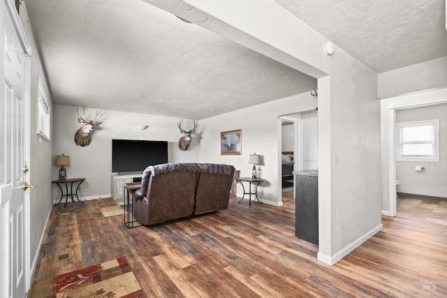 living room featuring visible vents, baseboards, and wood finished floors