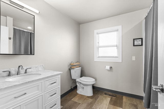 full bath featuring visible vents, toilet, vanity, wood finished floors, and baseboards