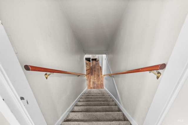 stairway featuring baseboards and wood finished floors