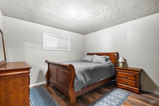 bedroom with a textured ceiling, wood finished floors, and baseboards