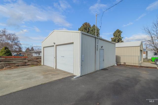 detached garage featuring fence