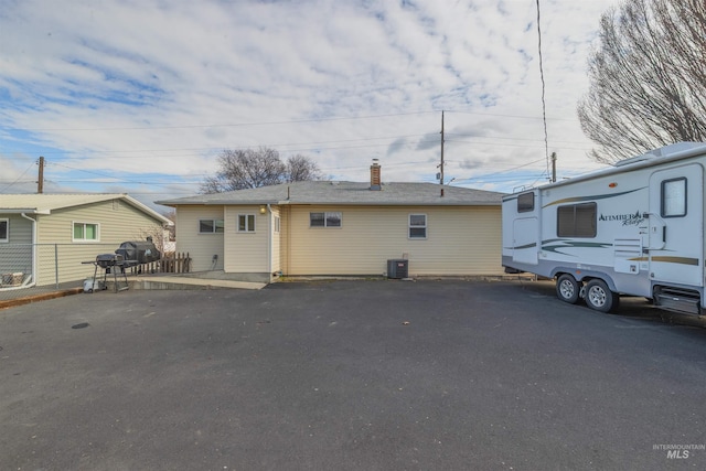 view of front of house featuring fence and central AC unit