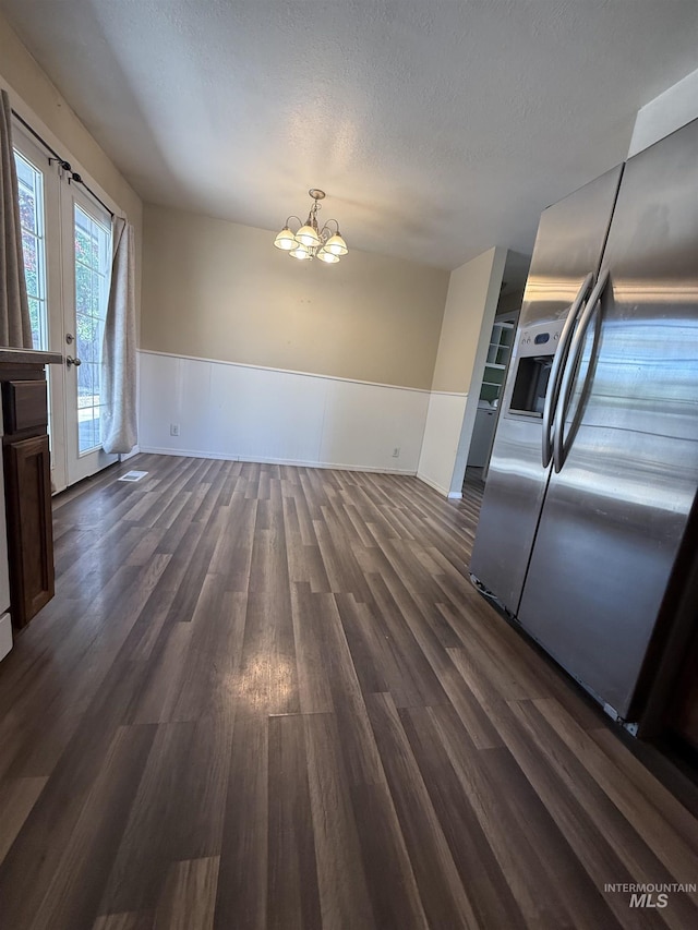 10342 W Ardyce St, Boise, ID 83704 - unfurnished dining area featuring a chandelier, dark wood finished floors, wainscoting, and a textured ceiling