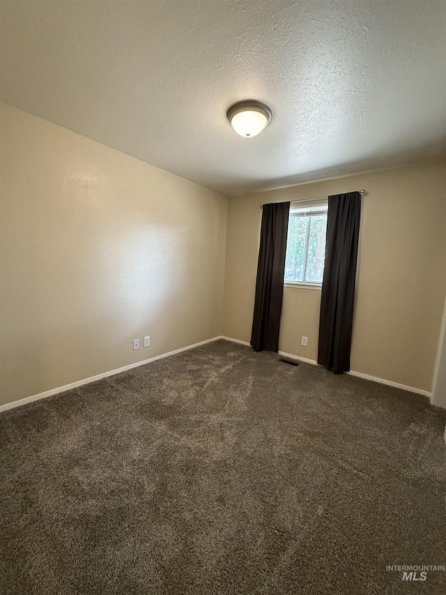 10342 W Ardyce St, Boise, ID 83704 - spare room with a textured ceiling, dark carpet, and baseboards