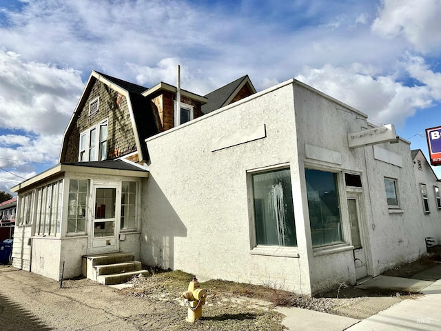 view of property exterior with a sunroom