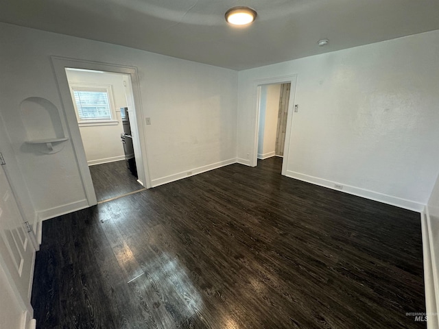 unfurnished room featuring dark wood-type flooring