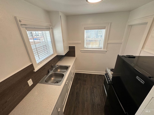 kitchen featuring white cabinets, black range with electric stovetop, dark wood-type flooring, and sink