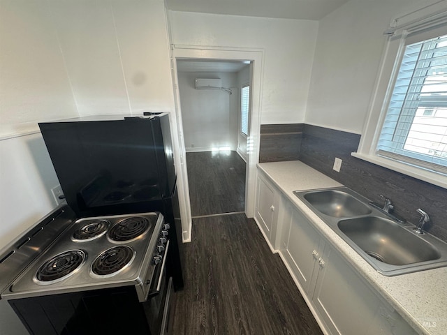 kitchen featuring white cabinetry, sink, a healthy amount of sunlight, dark hardwood / wood-style floors, and electric stove