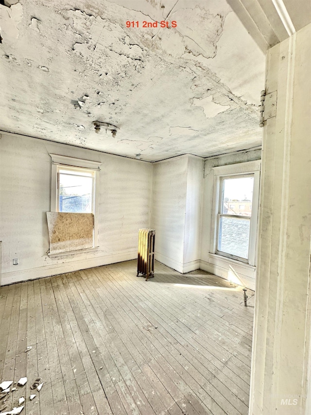 miscellaneous room with hardwood / wood-style floors and radiator heating unit