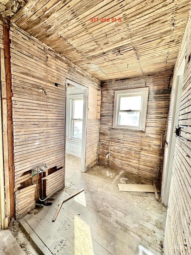 interior space featuring wooden ceiling and wood walls