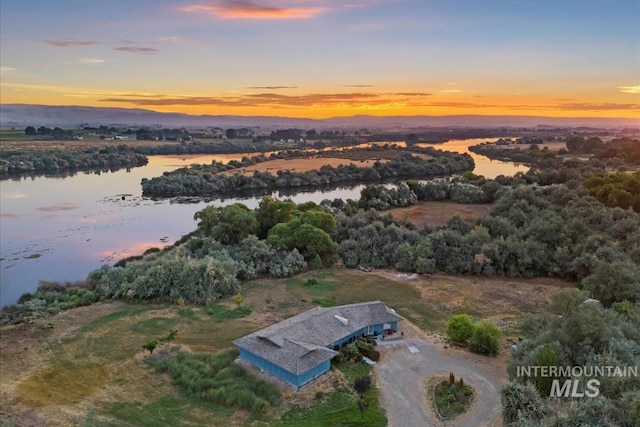 aerial view at dusk featuring a water view