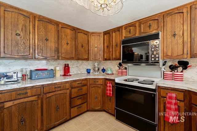 23743 Viking Ln, Wilder, ID 83676 - kitchen featuring black microwave, range with electric stovetop, brown cabinets, and light countertops