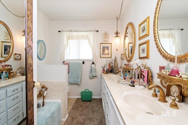 23743 Viking Ln, Wilder, ID 83676 - bathroom featuring double vanity, toilet, baseboards, and a bathtub