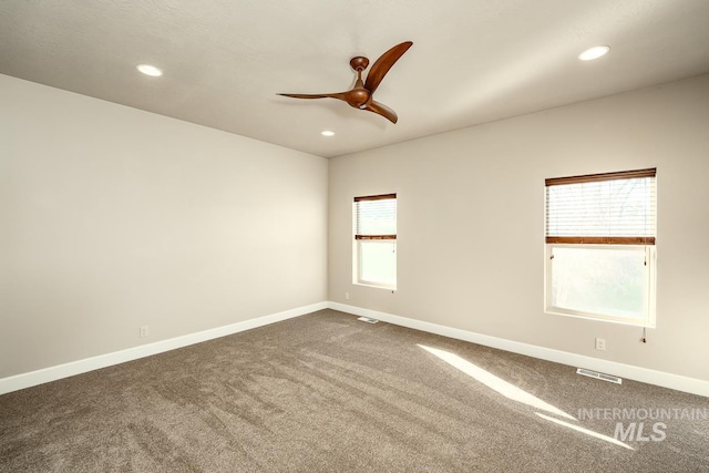 spare room featuring ceiling fan, recessed lighting, dark carpet, and baseboards