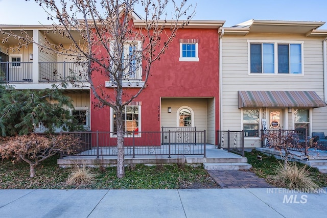 multi unit property featuring a porch and stucco siding