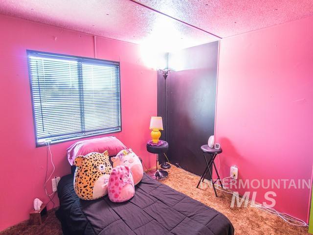 bedroom featuring a textured ceiling and carpet flooring