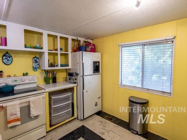 kitchen with white appliances and a textured ceiling