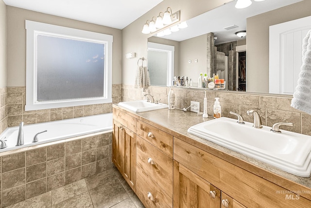 bathroom with vanity and tiled tub