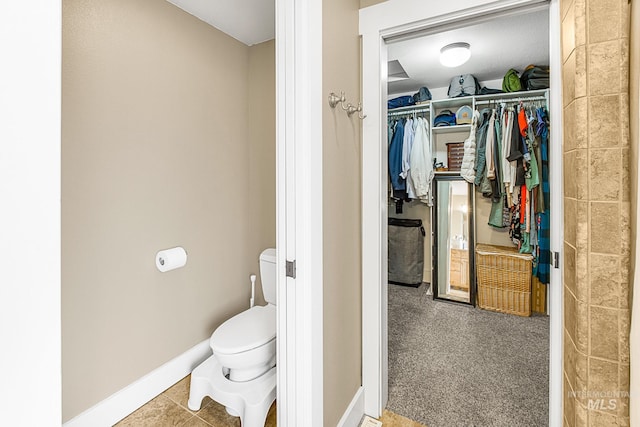 bathroom featuring toilet and tile patterned flooring