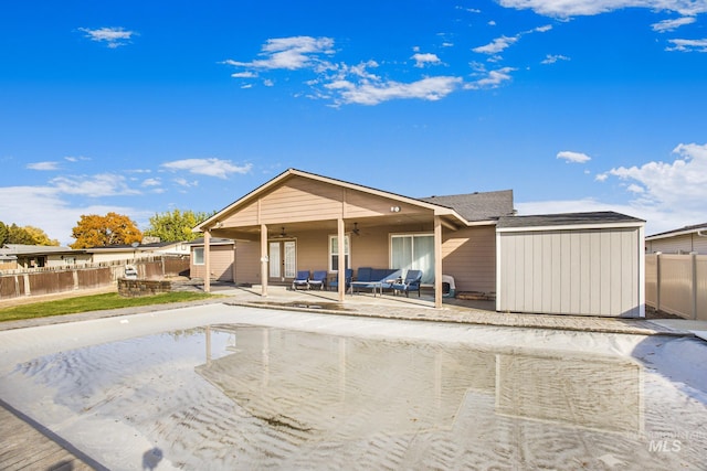 rear view of house with a patio area, ceiling fan, and a storage shed