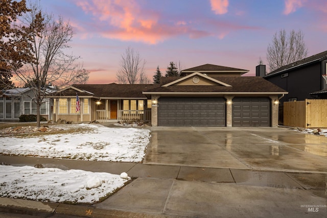 view of front facade featuring concrete driveway, brick siding, an attached garage, and fence