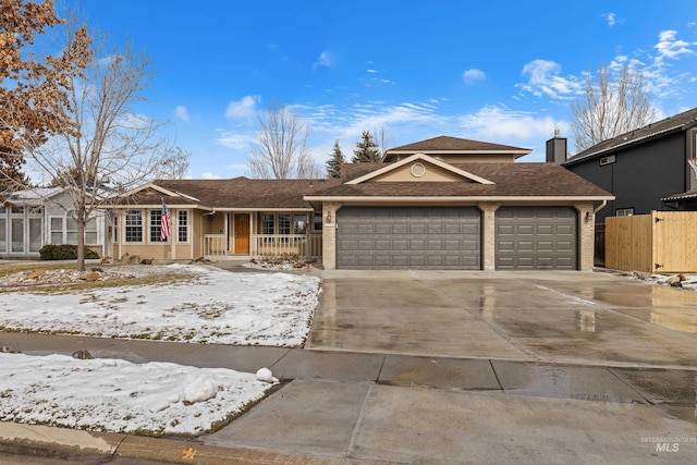 view of front of house with a garage, brick siding, driveway, and fence