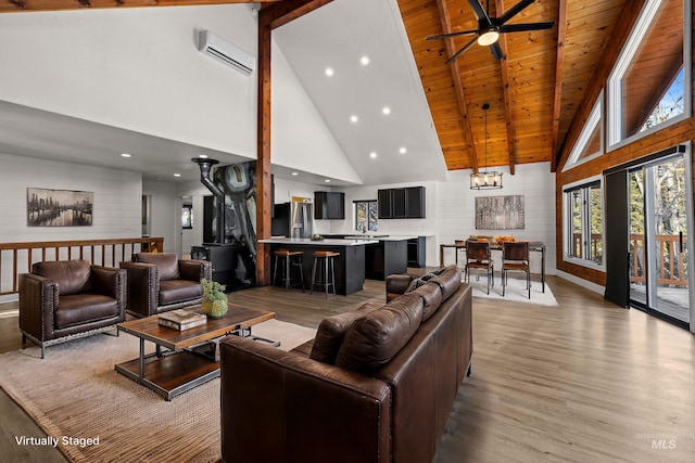 living room featuring a wall mounted AC, high vaulted ceiling, wooden ceiling, light wood-type flooring, and beam ceiling