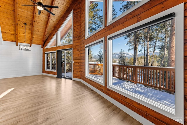 unfurnished sunroom with ceiling fan with notable chandelier, lofted ceiling with beams, and wooden ceiling