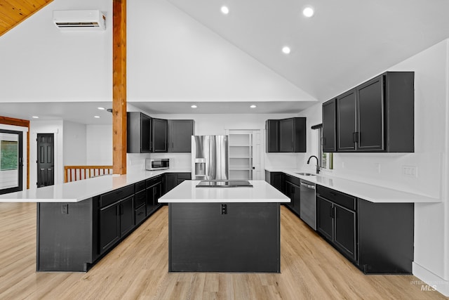 kitchen featuring a kitchen island, a wall mounted air conditioner, high vaulted ceiling, stainless steel appliances, and light wood-type flooring