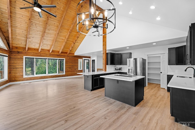 kitchen with beamed ceiling, a center island, wooden ceiling, and wooden walls