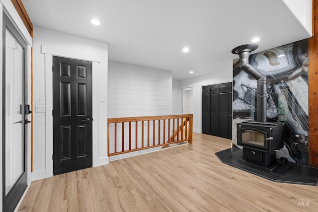 interior space featuring light hardwood / wood-style floors and a wood stove