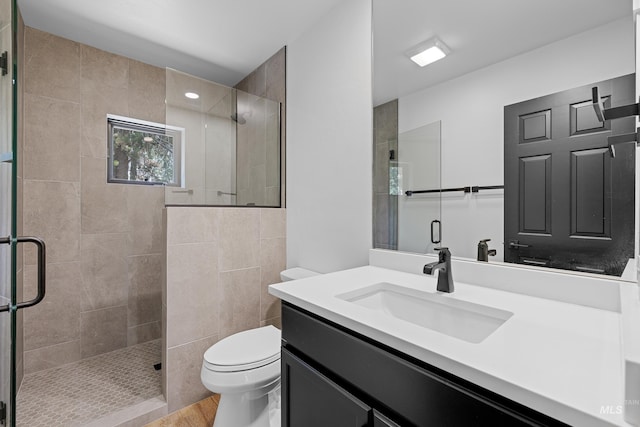 bathroom with vanity, hardwood / wood-style floors, walk in shower, and toilet