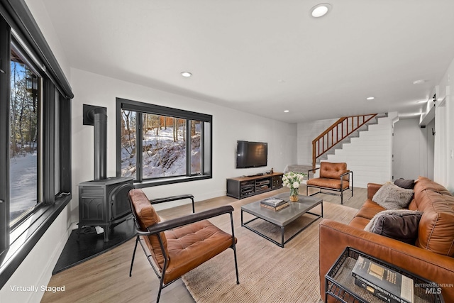 living room with light hardwood / wood-style flooring and a wood stove