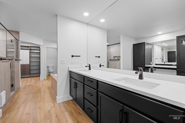 bathroom featuring vanity, toilet, an enclosed shower, and hardwood / wood-style floors