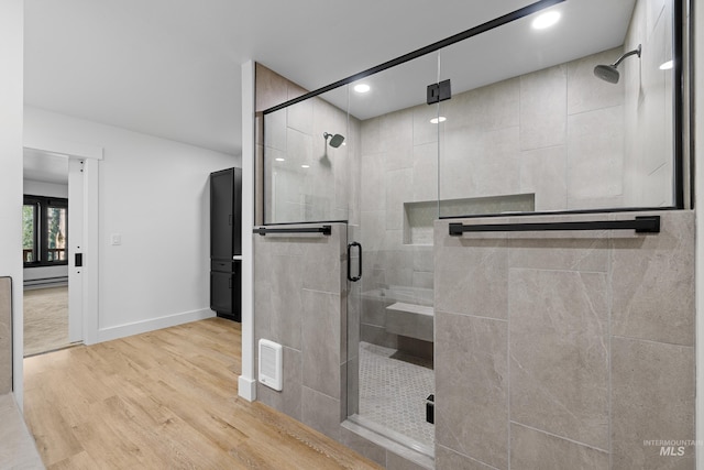 bathroom featuring hardwood / wood-style floors and a shower with door