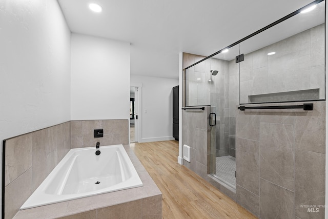 bathroom with shower with separate bathtub and hardwood / wood-style floors