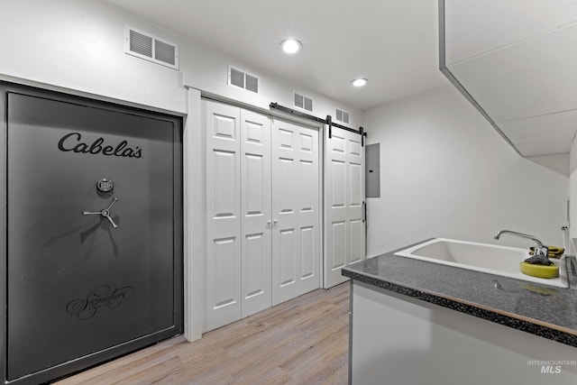 kitchen featuring sink, light hardwood / wood-style floors, and a barn door