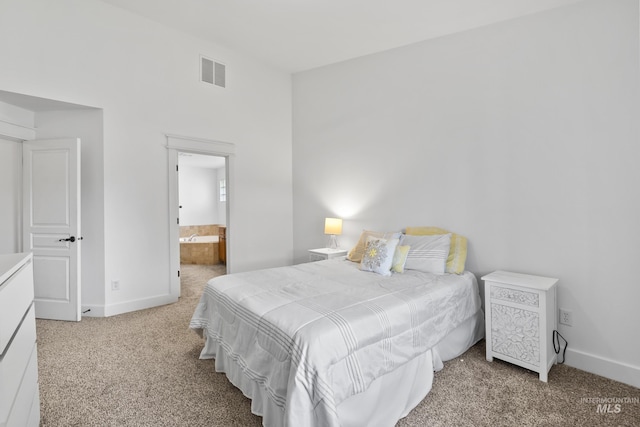 carpeted bedroom featuring baseboards and connected bathroom