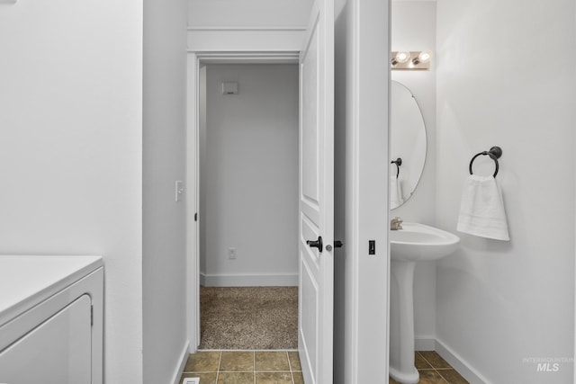 bathroom with washer and dryer and baseboards