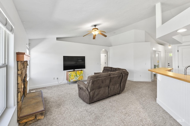 living room with lofted ceiling, a ceiling fan, carpet floors, a fireplace, and baseboards