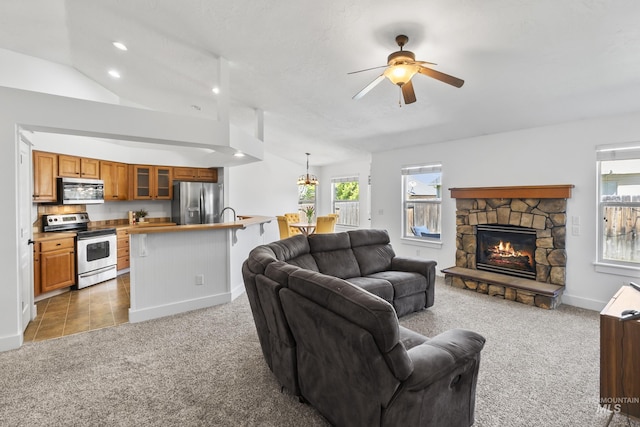 living room with light carpet, ceiling fan, a fireplace, baseboards, and recessed lighting